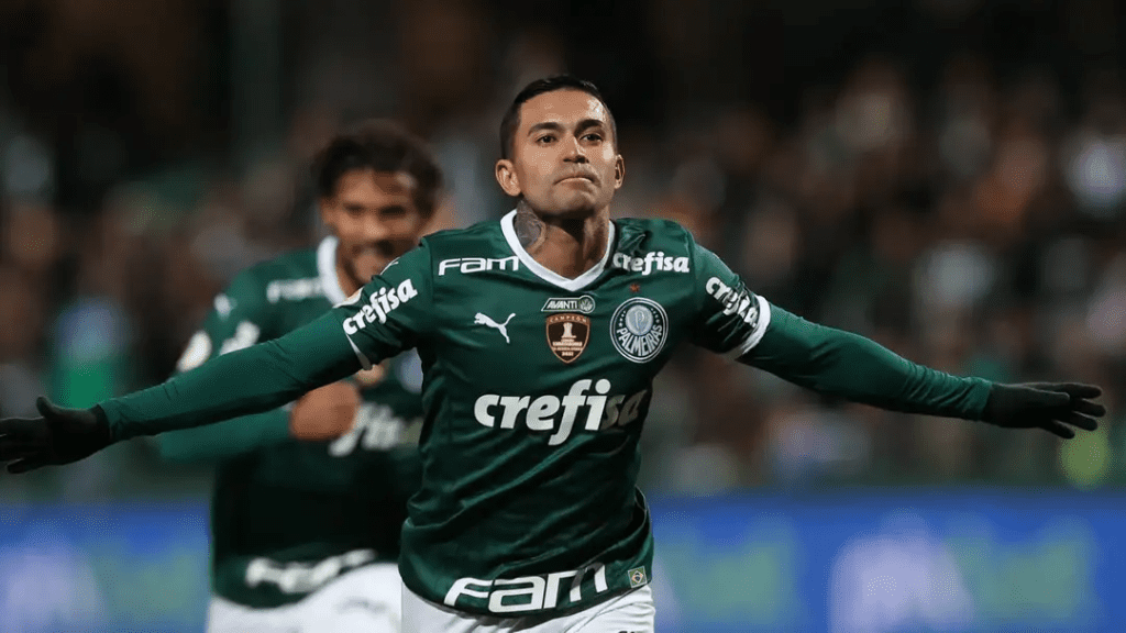 Jogador do Palmeiras, Dudu, correndo com os braços abertos comemorando gol marcado.