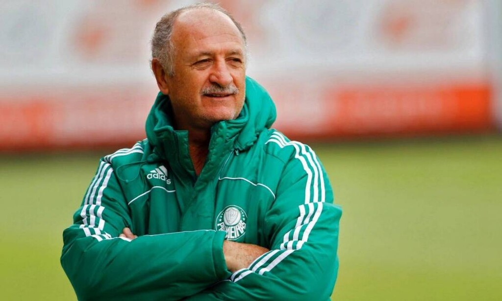 Ex-técnico do Palmeiras, Felipão, com uniforme do time no gramado.