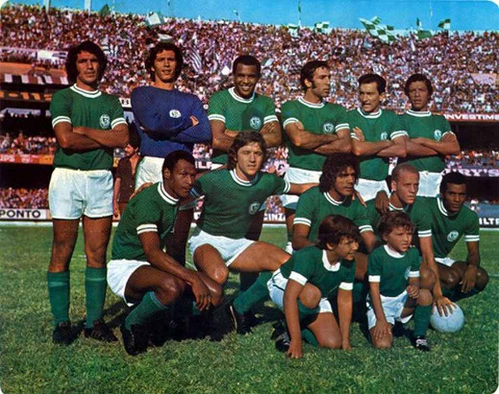 Elenco da segunda academia do Palmeiras enfileirado em campo com estádio lotado antes do jogo.