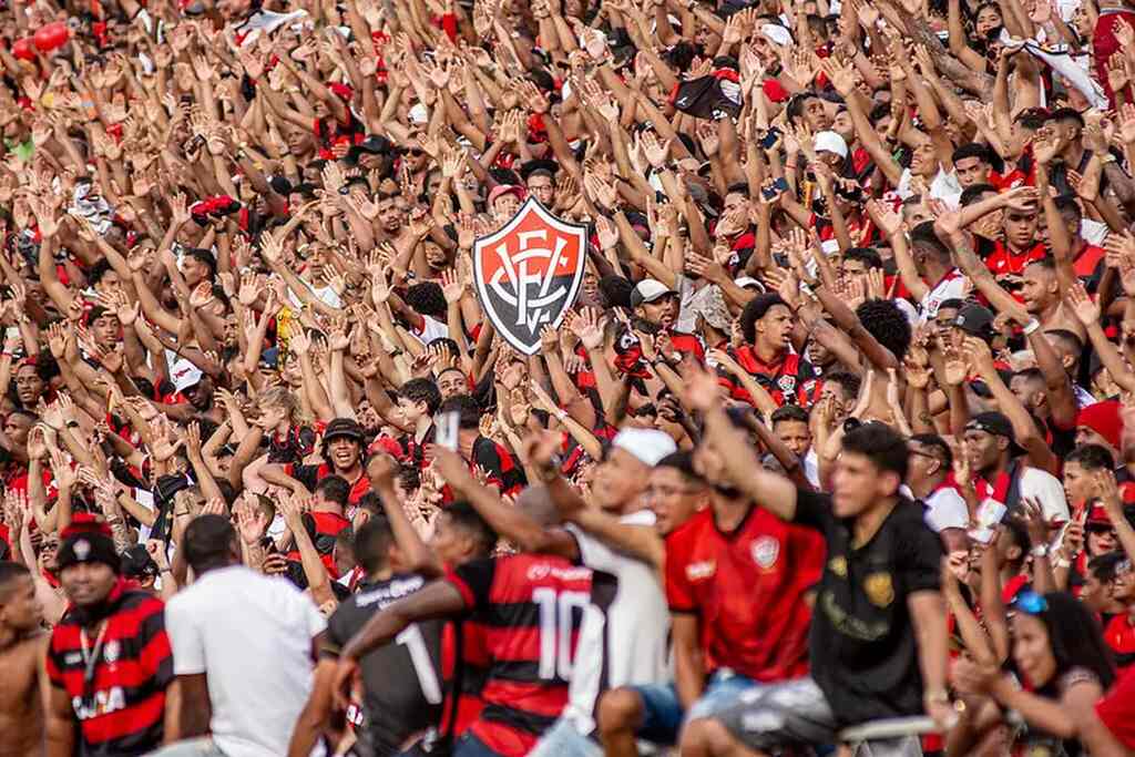 Torcida do Vitória durante partida de futebol com o estádio lotado.