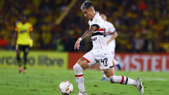 Jogador em campo conduzindo bola