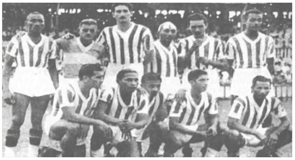 Parte do elenco do Paysandu em 1945, enfileirados em campo antes da partida em preto e branco.