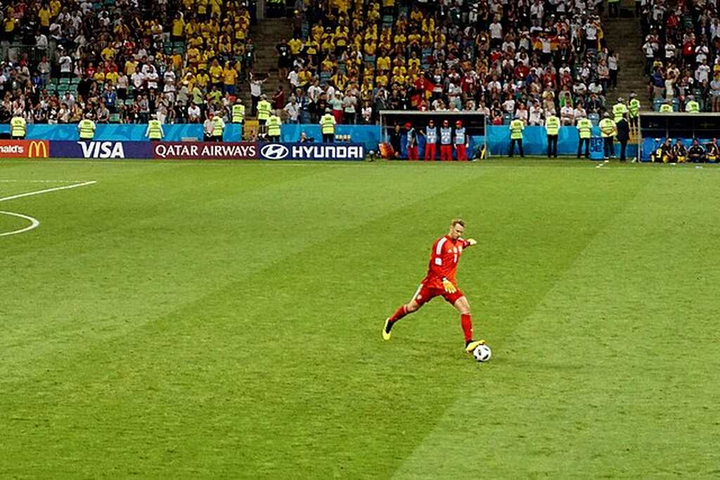 Goleiro Manuel Neuer, de uniforme vermelho, realizando cobrança de bola parada na partida.