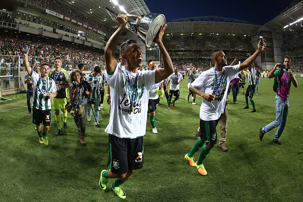 Jogador do América levantando uma taça de campeão - Foto: Divulgação América FC