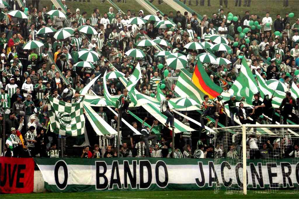 Torcida organizada do Juventude na arquibancada durante partida de futebol.