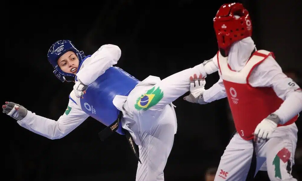 Imagem de duas atletas femininas da taekwondo disputando nas Olimpíadas