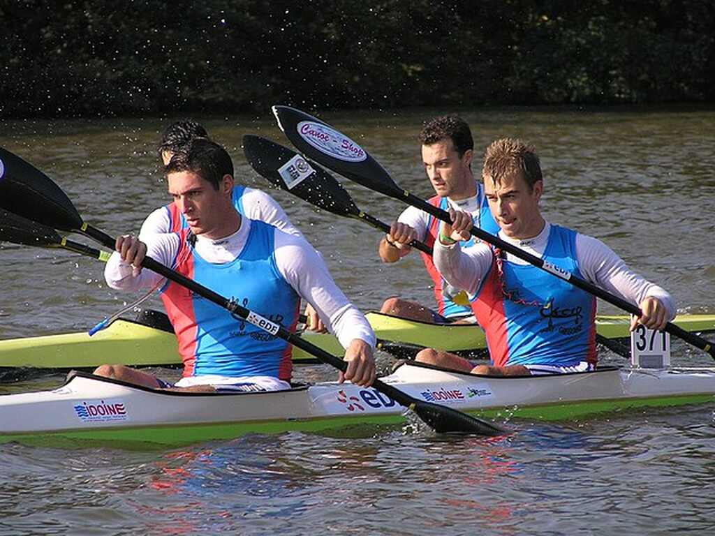 Imagem de três atletas praticando canoagem