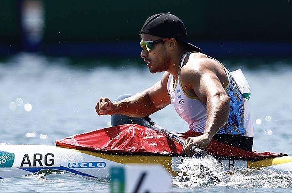 Atleta masculino praticando canoagem dentro da água