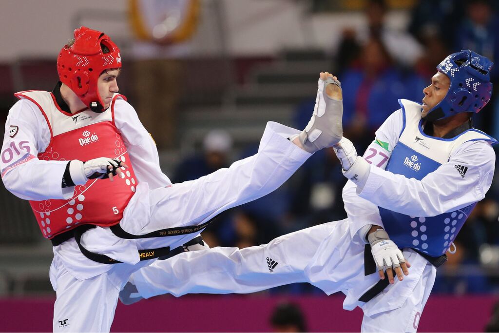 Imagem de dois atletas de taekwondo competindo