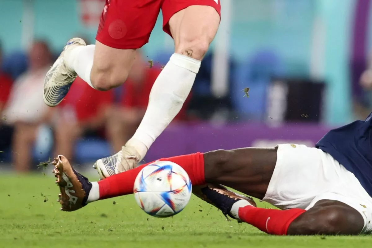 Dois jogadores de futebol chutando uma bola