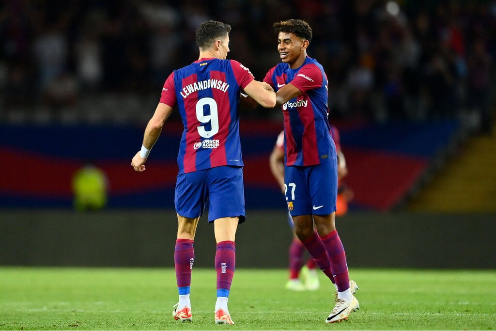 Imagem de dois jogadores do Barcelona em campo, inclusive Lewandowsk