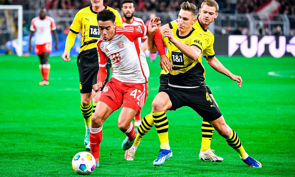 Jogadores do Bayern de Munique e Borussia Dortmundo disputando a bola em campo, no Der Klassiker