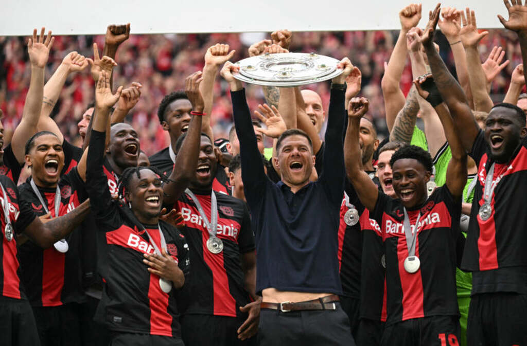 Jogadores e técnico do Bayer Leverkusen erguendo a taça de campeões da Bundesliga 2023/24