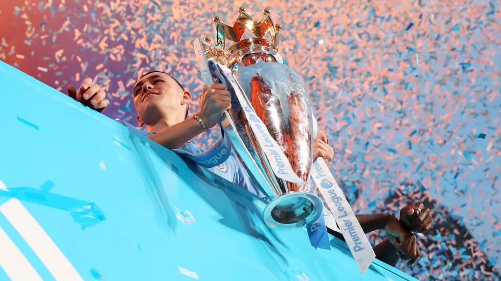 Imagem do jogador do Manchester City, Phil Foden, segurando a taça da vitória do campeonato