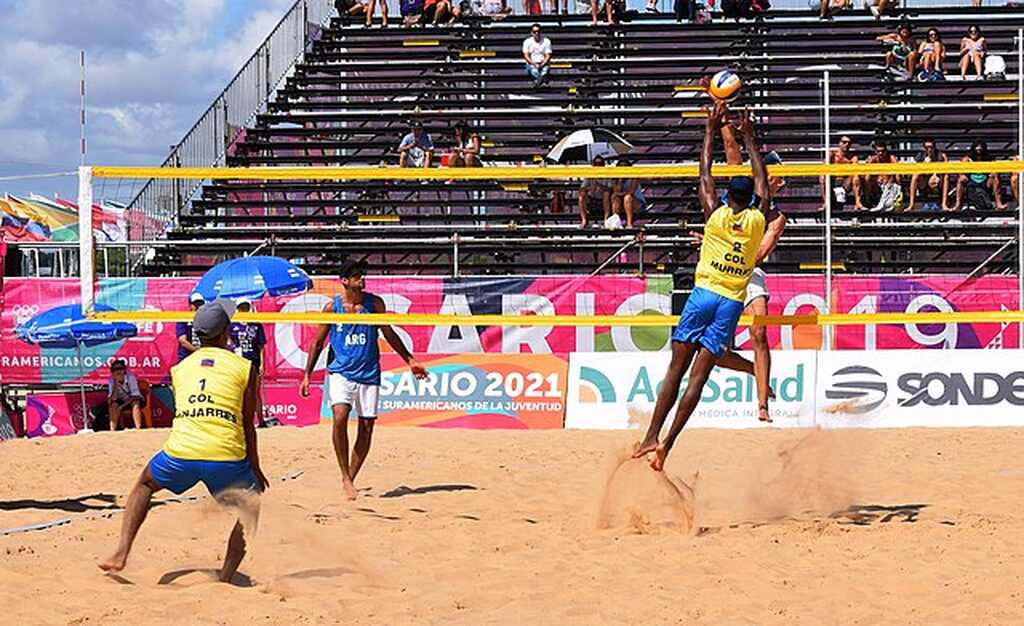 Imagem de duas duplas competindo em uma partida de volei de praia