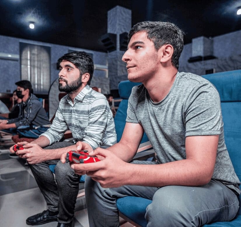 Dois jogadores de esoccer competem entre si com dois controles de videogame