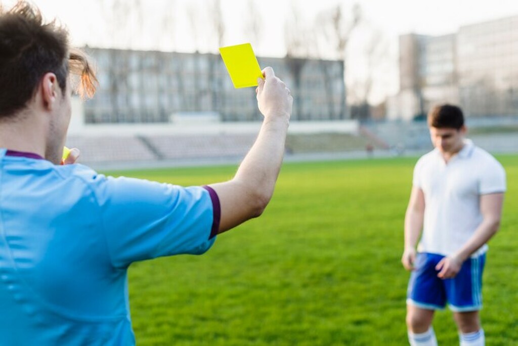 a arbitragem levanta um cartão amarelo para o jogador em uma partida