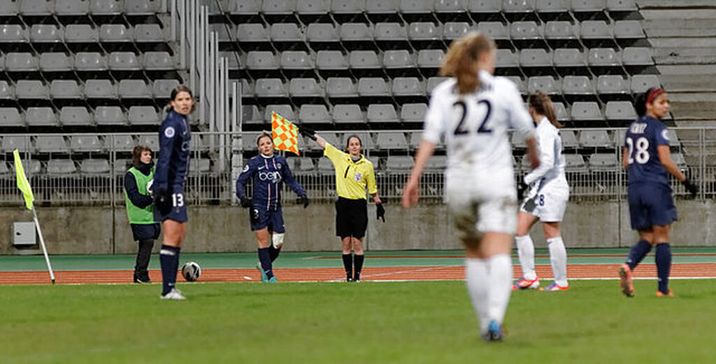 a arbitragem levanta a bandeira em uma partida de futebol feminino