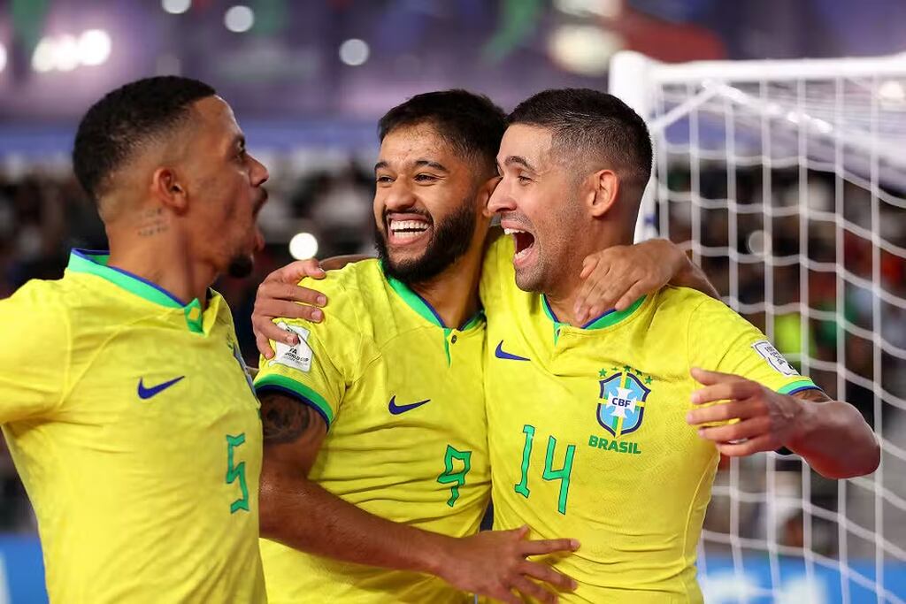 parte da equipe da seleção brasileira de futsal comemorando o gol em quadra