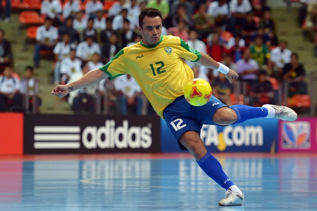 falcao, um dos maiores da historia da copa do mundo de futsal, prestes a chutar uma bola em quadra pela seleção brasileira