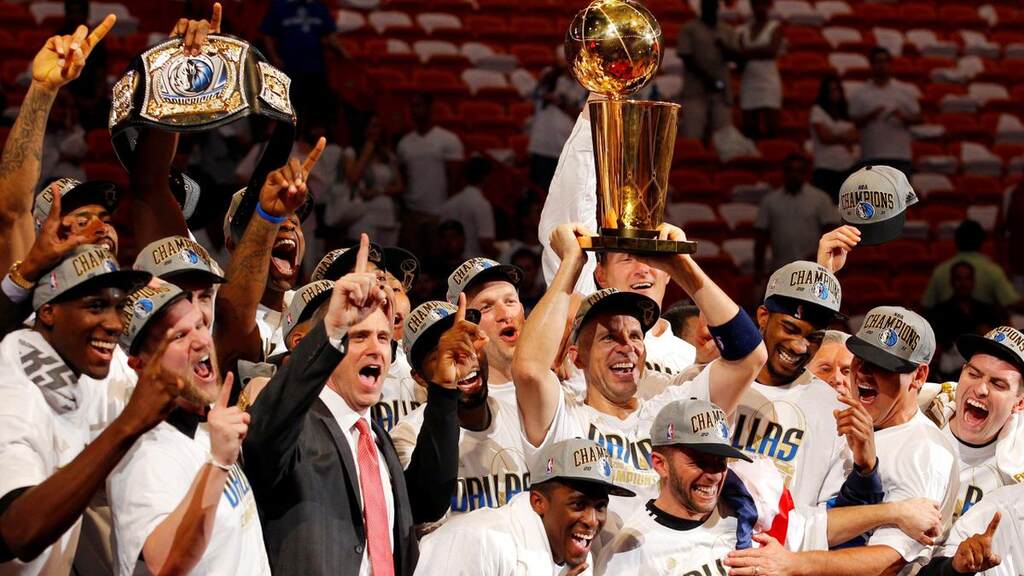 elenco de 2011 com a taça da nba erguida, parte da história Dallas Mavericks