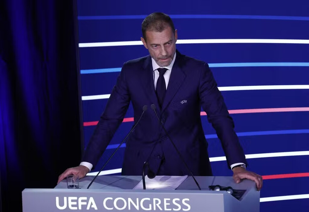 presidente da UEFA anunciando a nova champions em frente a um palanque