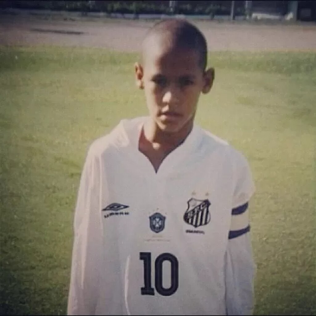 neymar com a camisa da base do santos, posado para a foto no gramado. o time é o primeiro da historia de neymar jr