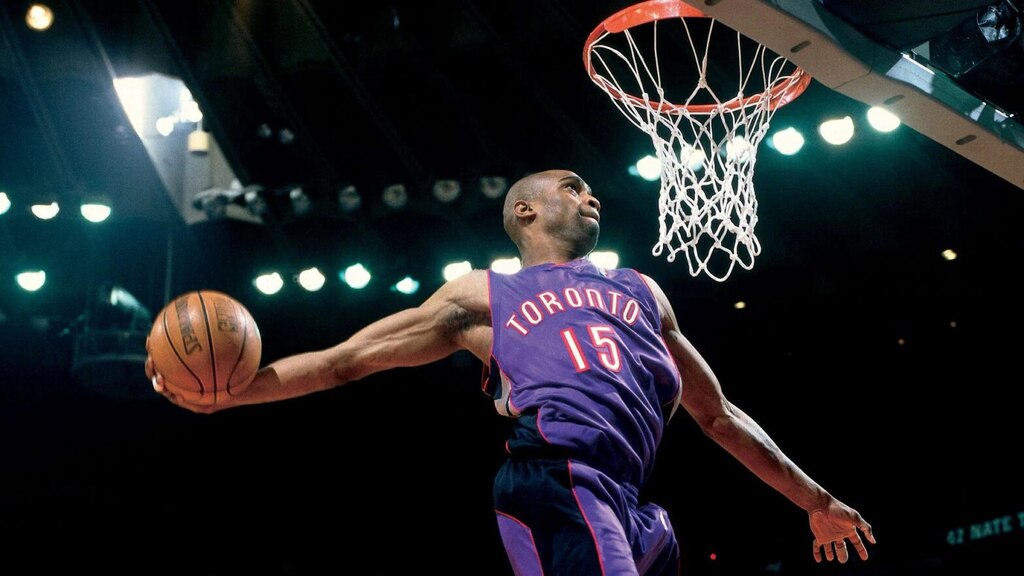 vince carter prestes a fazer uma cesta em quadra. o atleta é um dos melhores da historia toronto raptors