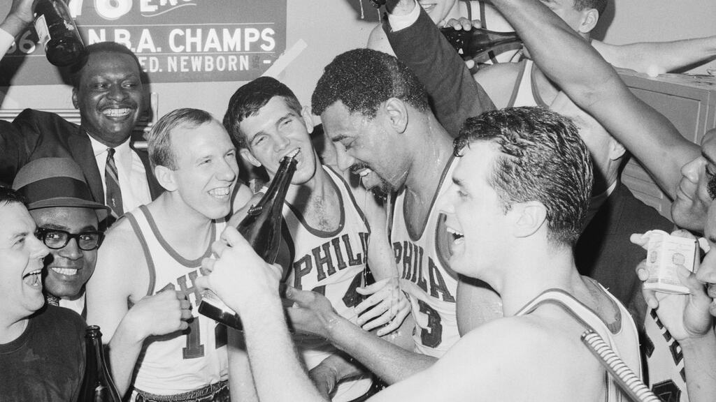 parte do elenco de 1966/67 do Philadelphia 76ers historia, rindo e comemorando o titulo da nba