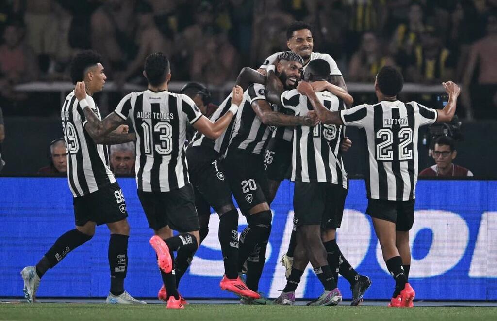 parte do time do botafogo comemorando gol em campo. o clube ja recebey mais de 90 milhoes na premiação da libertadores