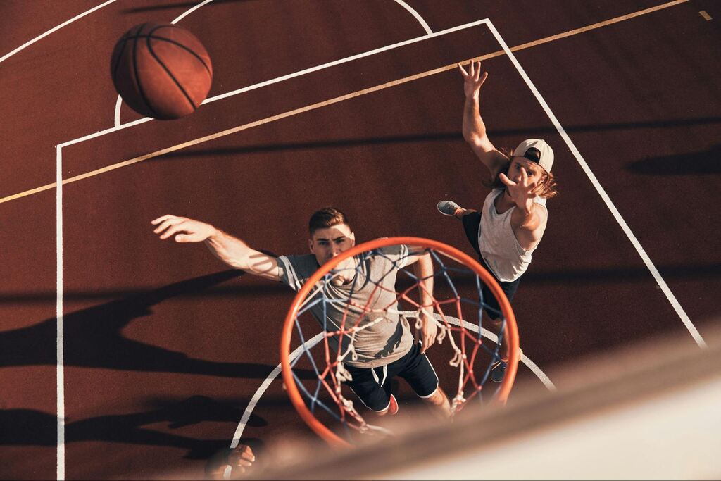 jogadores de basquete fazendo cesta apos uma aposta em cesta de tres pontos