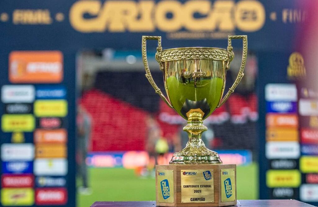 taça do cariocao ao lado do gramado, representando Apostas em campeonatos estaduais