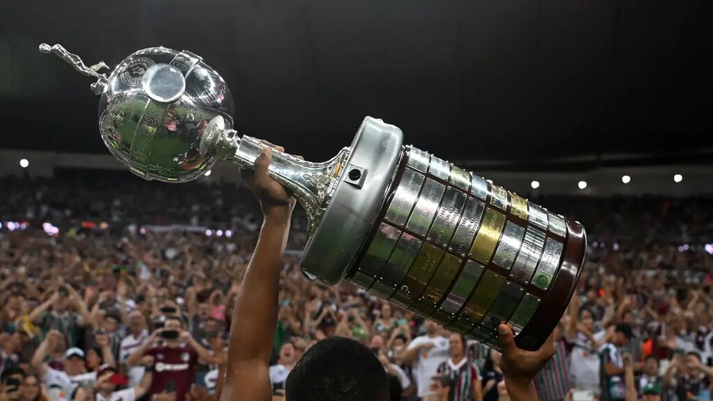 taça da copa libertadores, um dos campeonatos mais importantes do futebol, erguida em frente a torcida