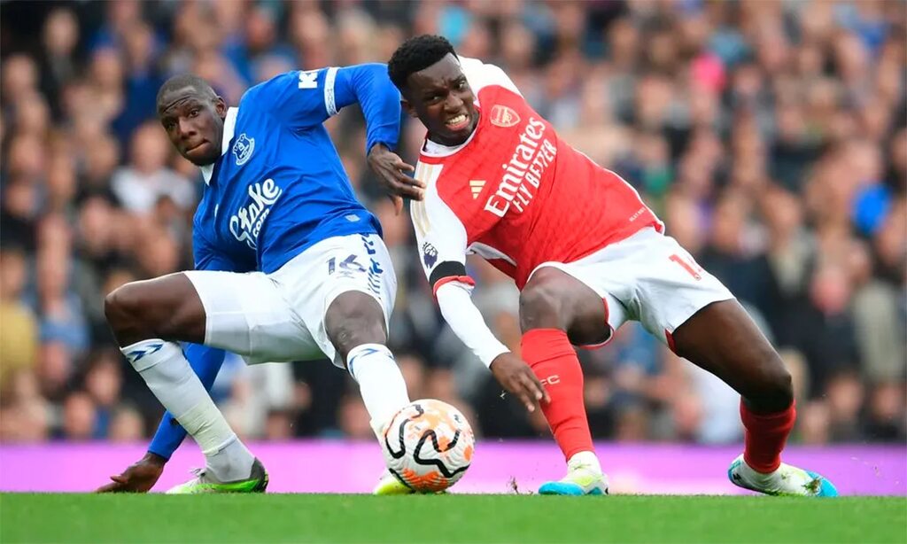 jogadores do arsenal e everton, que sabem Como apostar em último gol, disputam a bola em campo