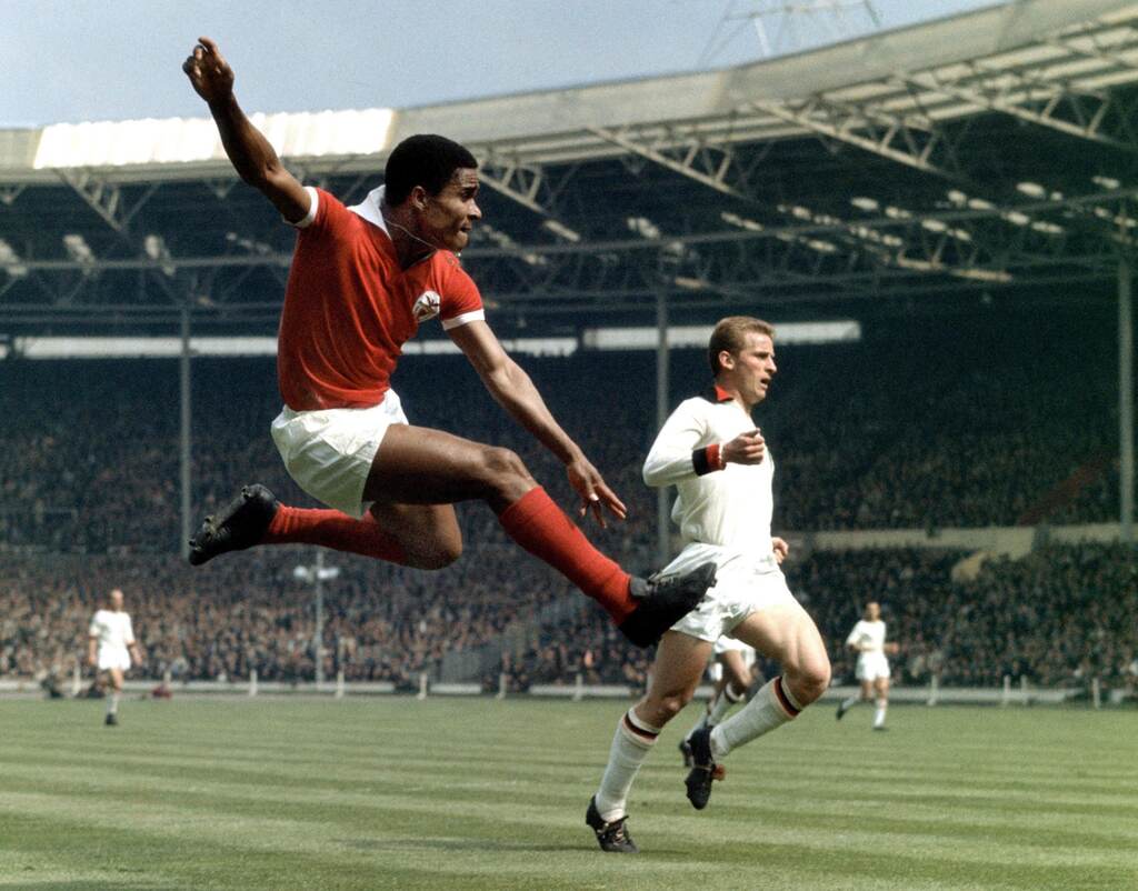 eusebio, um dos melhores finalizadores do futebol, chutando uma bola no ar em campo pelo benfica