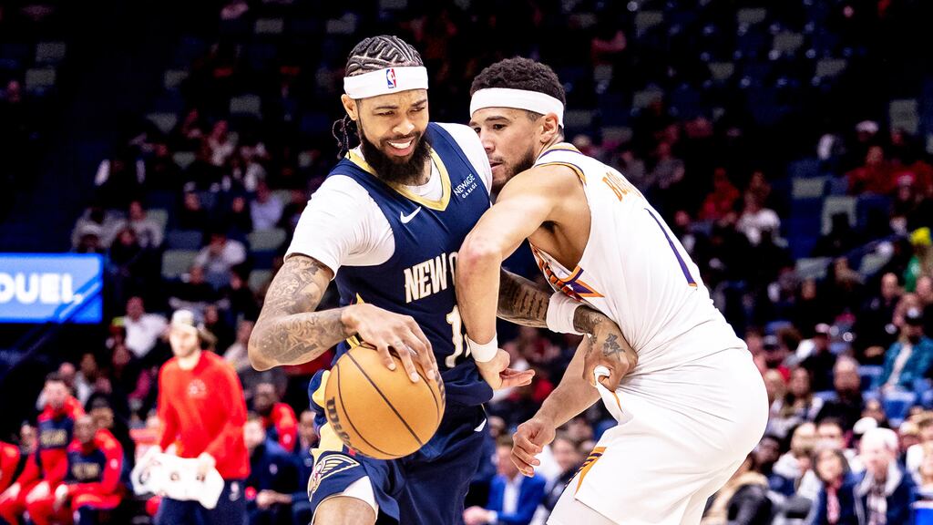 jogador do new orleans pelicans enfrentando outro do phoenix suns em quadra