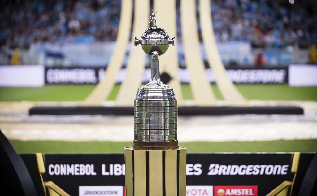 taça de o que é a libertadores posta em frente ao gramado prestes de um jogo do campeonato acontecer