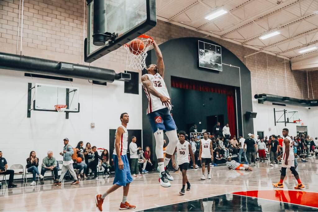 jogador fazendo uma cesta em quadra, representando o que significa quarto no basquete