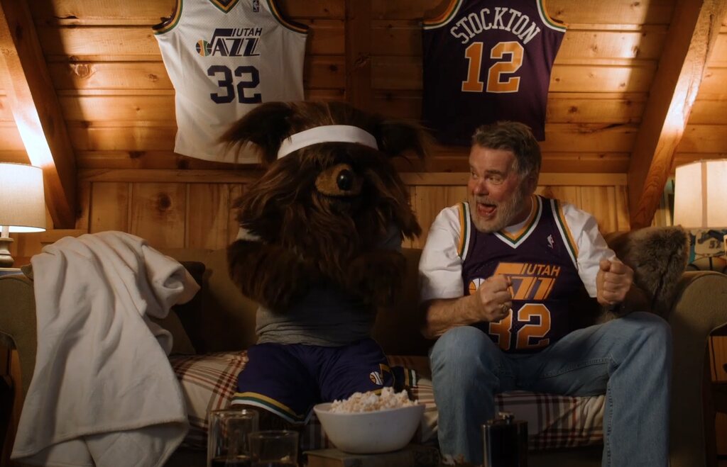 mascote do utah jazz historia sentado no sofá com um fã do time