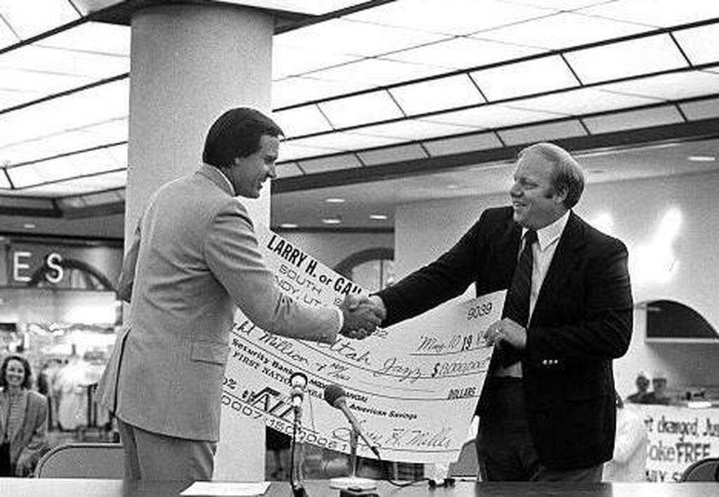 fundadores da utah jazz historia apertando maos, com um cheque ao fundo