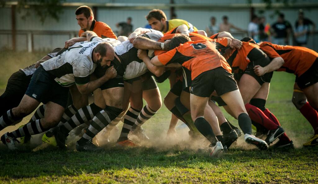 jogadores de rugby jogando o esporte no gramado. a forma de jogar é uma diferente entre rugby e futebol americano