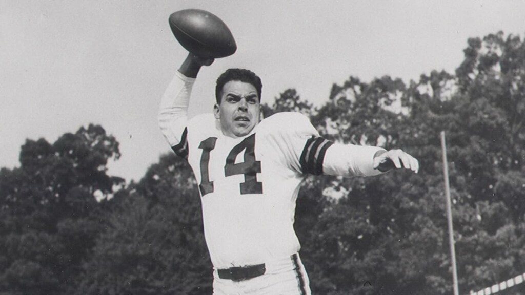 otto graham prestes a lançar uma bola de FA em campo, o jogador está entre os maiores quarterbacks da historia