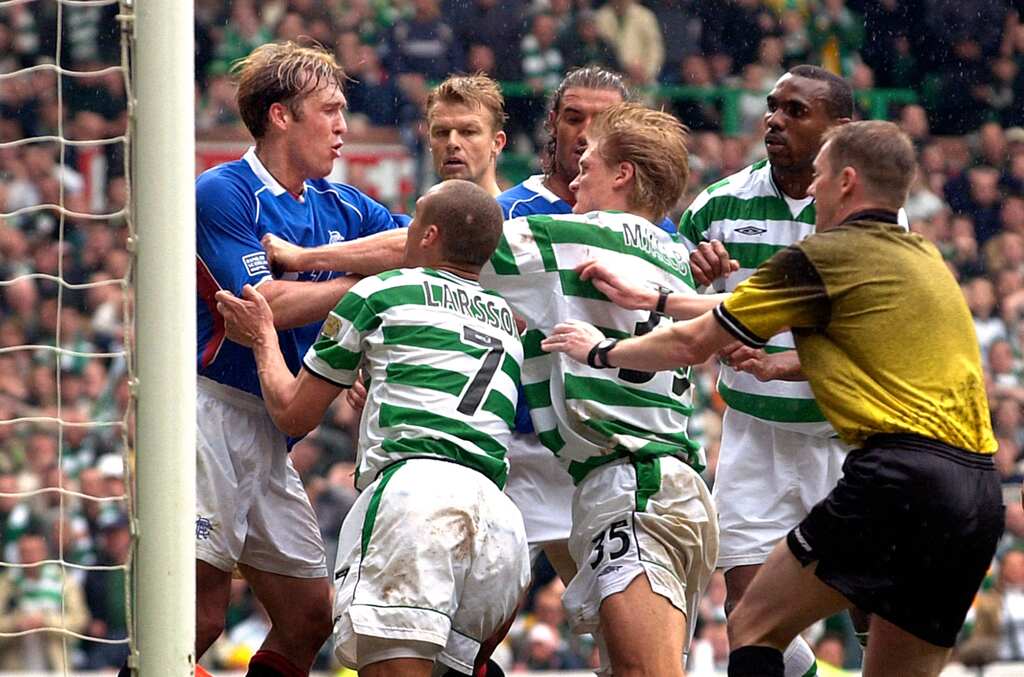 jogadores do celtic e rangers se enfrentando em campo, em uma das maiores rivalidades do futebol mundial