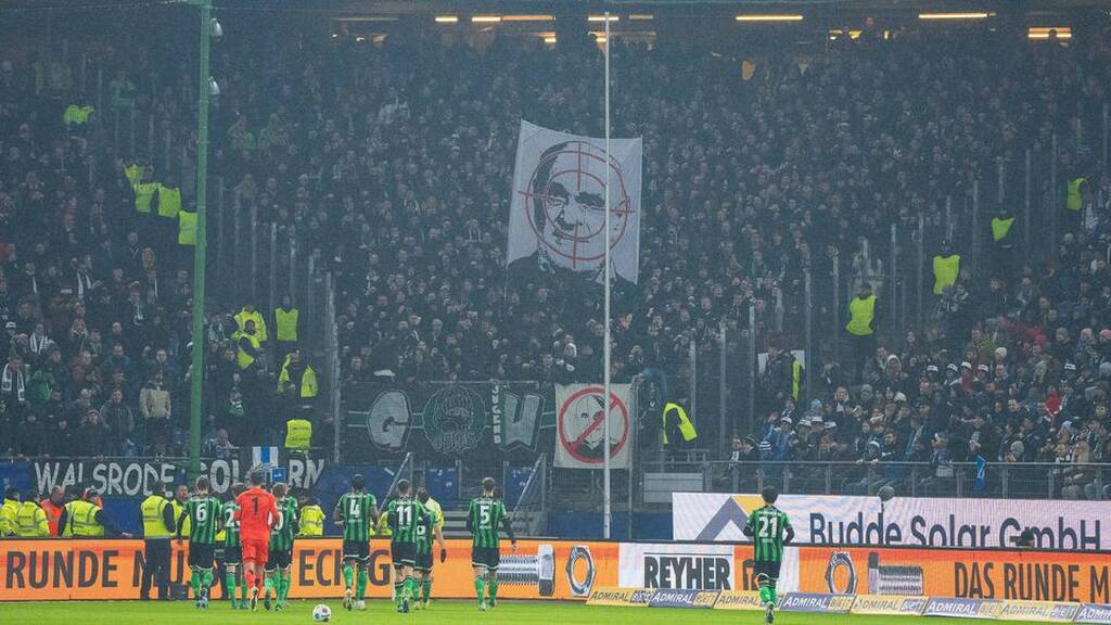 torcedores de um time da bundesliga 2 fazendo um protesto na arquibancada, com um cartaz