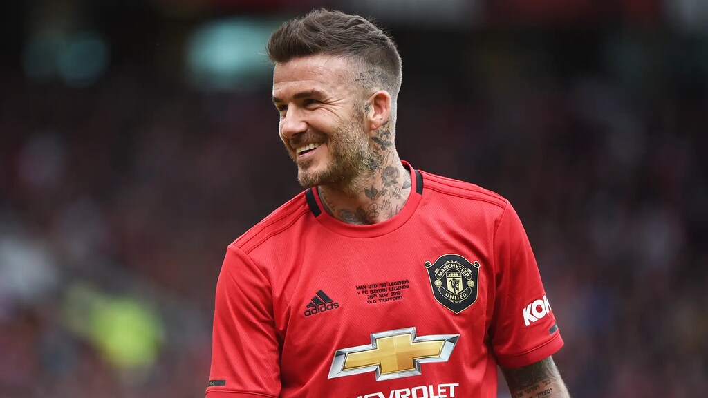 david beckham em campo pelo manchester united. ele é um dos Jogadores com mais assistências na história do futebol​