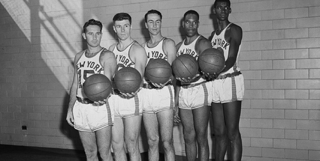 parte do elenco de 1950 do new york knicks historia, cada um com uma bola de basquete na mao e posado para uma foto